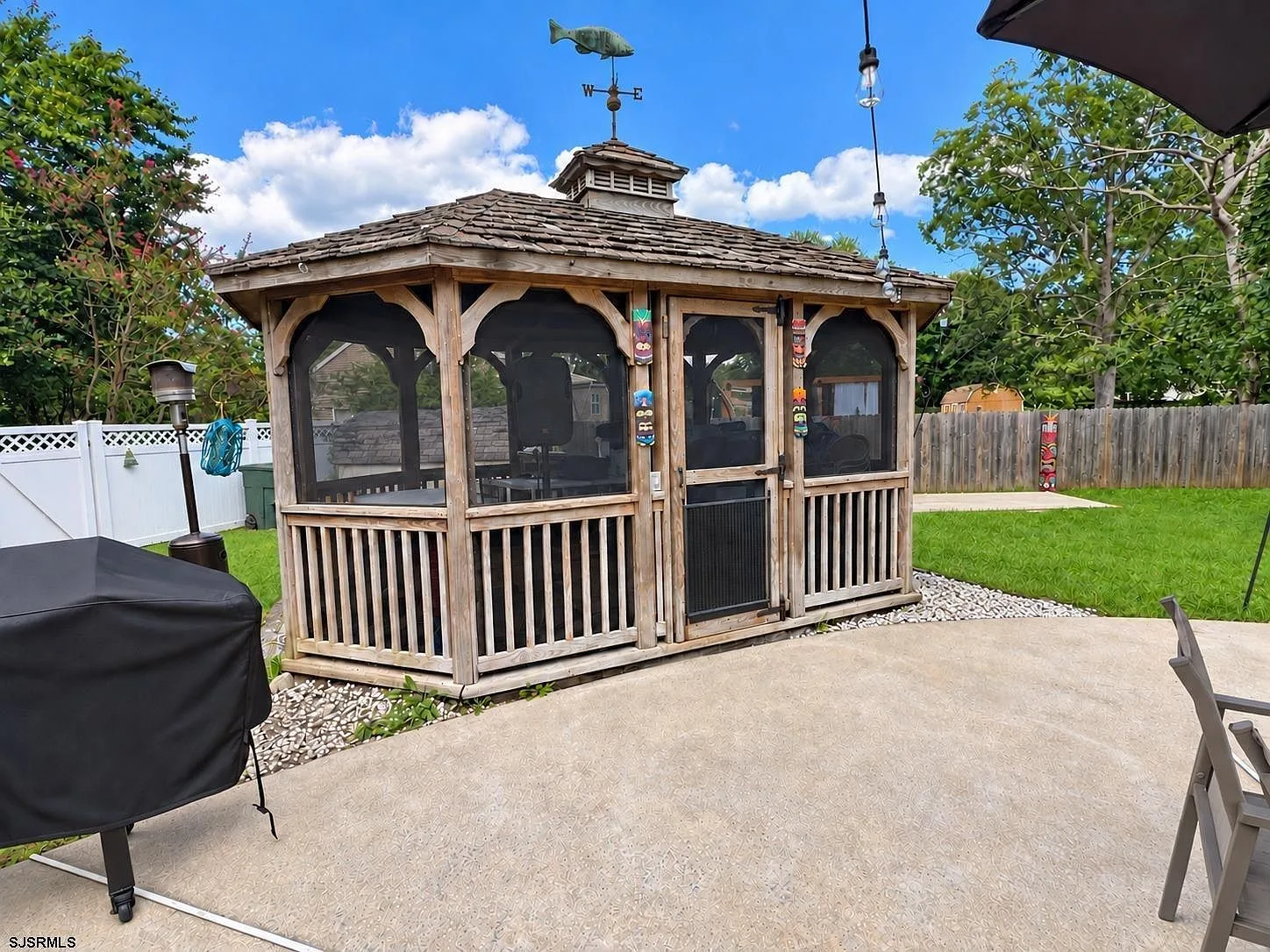 Wooden screened gazebo on the concrete patio