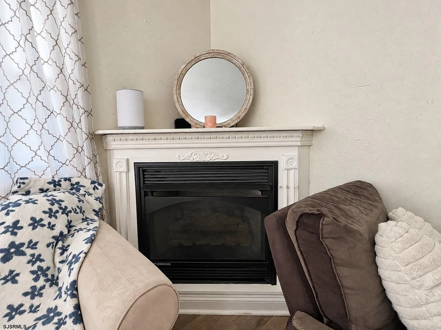 Corner fireplace with a white mantel in the living room