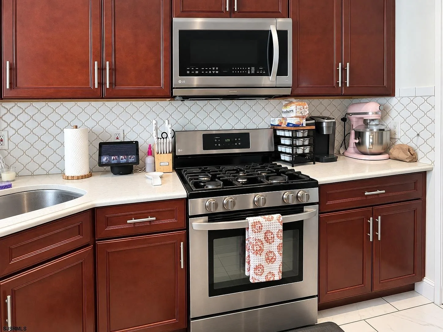 Kitchen stove area with stainless steel range and tile backsplash