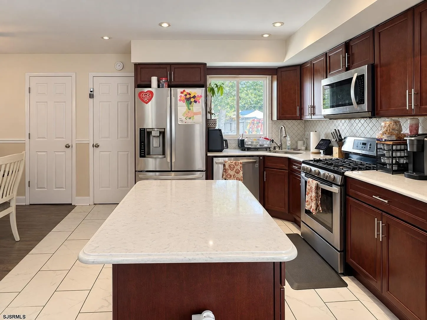Kitchen island with light countertops and dark cabinetry
