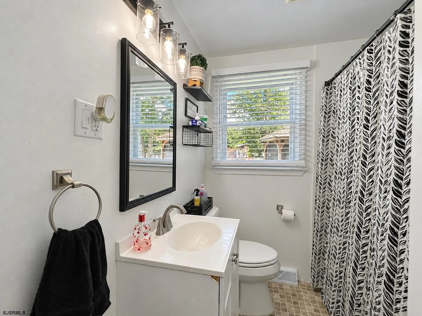 Full bathroom with white vanity and tiled tub area
