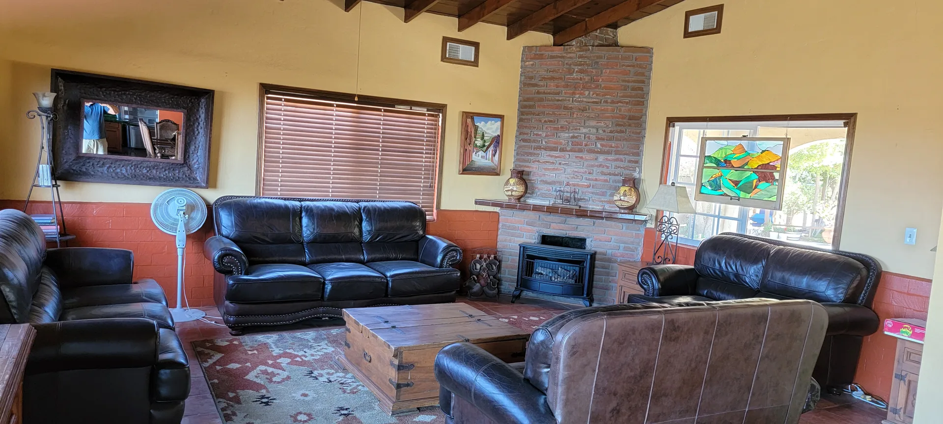 The rustic living room of the Hacienda with its wood fireplace at Rancho El Refugio