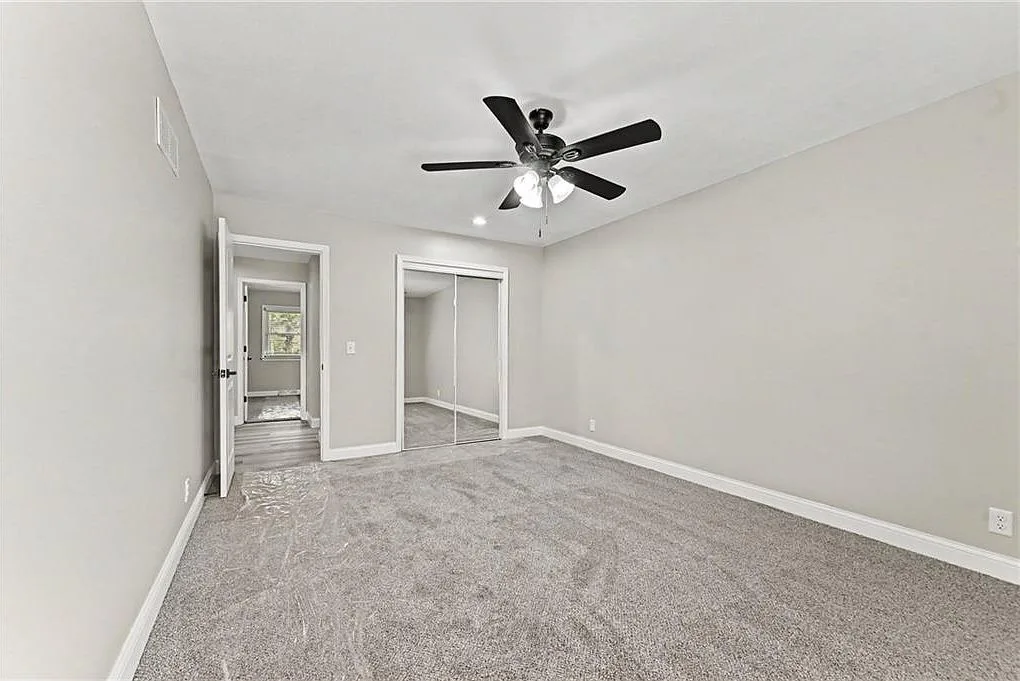 Renovated bedroom with grey carpet, light grey walls and white trim