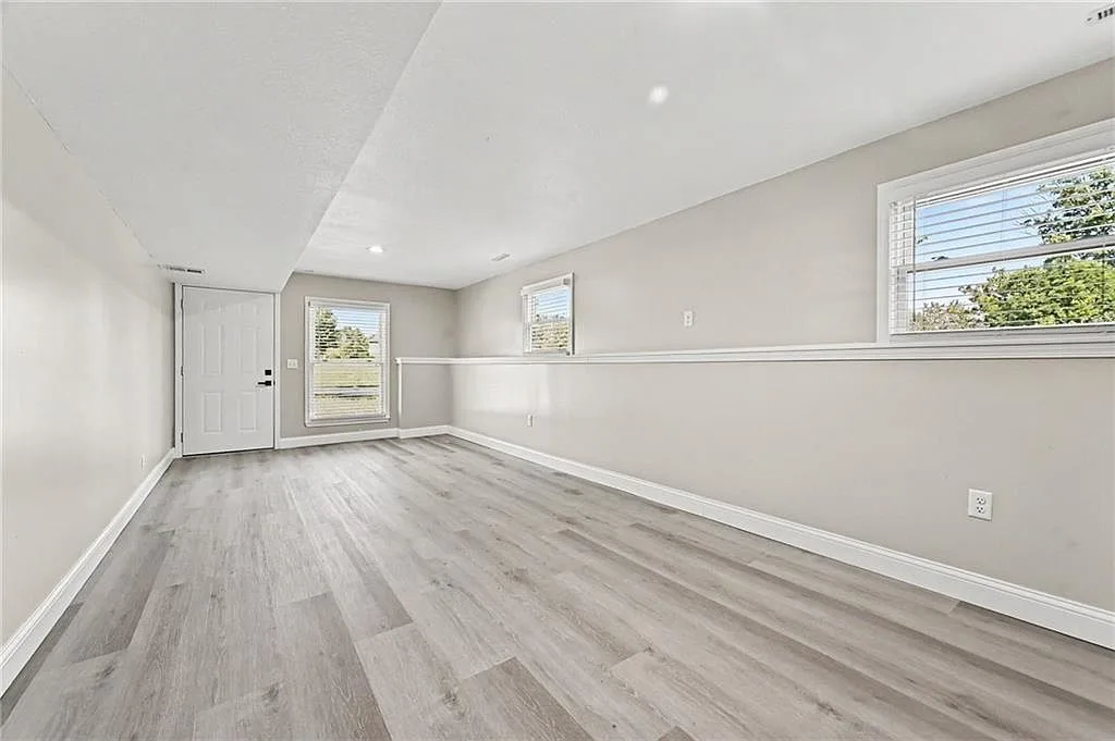 Additional bedroom with wood-look flooring and clear natural light