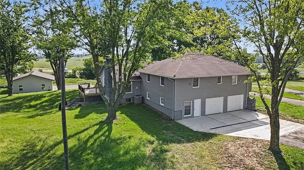 Aerial view of the ranch home showing the rear deck, basement garage bays and detached garage