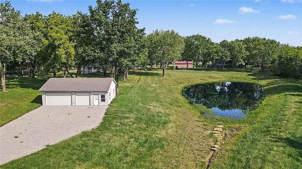 Aerial view of the detached garage with the private pond beside it in the open lawn