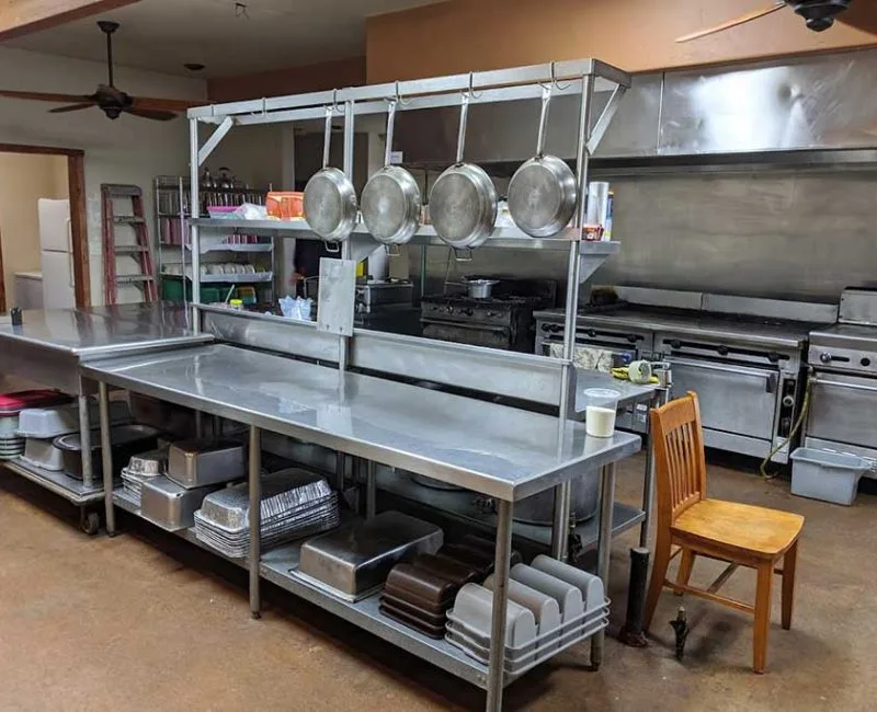 The Barn's commercial kitchen with stainless steel prep surfaces and professional ovens at Rancho El Refugio near Ensenada