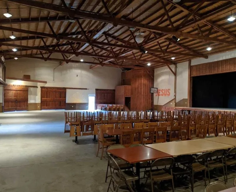 The Barn's large gathering hall at Rancho El Refugio near Ensenada, an open assembly space with exposed wood trusses and barn-style doors