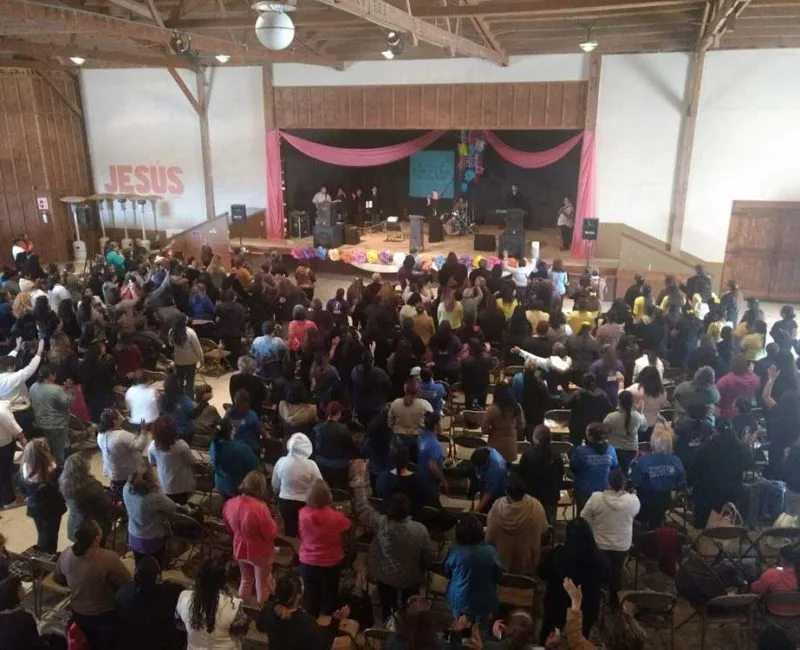 The Barn's large multi-purpose hall with exposed wood rafters and a raised stage at Rancho El Refugio near Ensenada