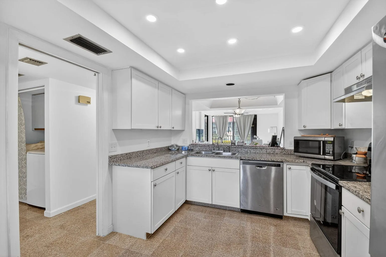 White kitchen with granite counters at 7030 Half Moon Circle #117, Hypoluxo