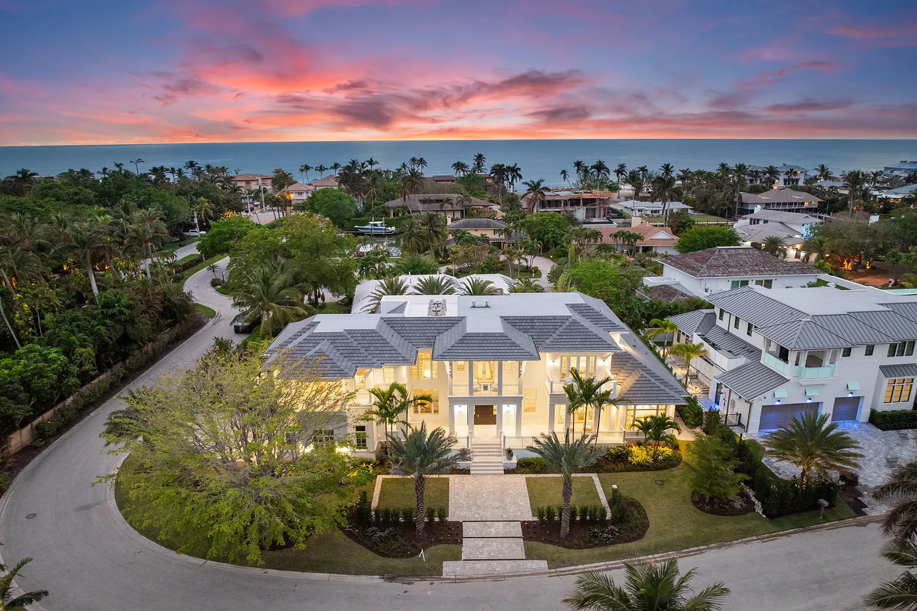 Luxury Naples estate at golden hour with palm-lined landscaping
