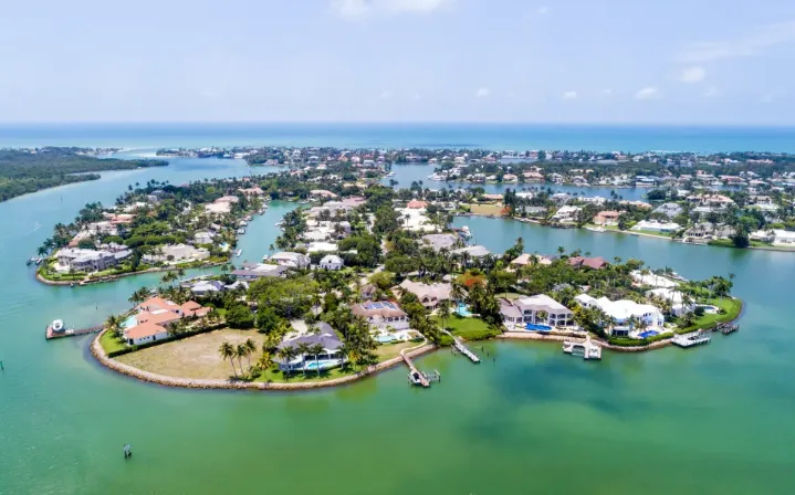 Aerial view of a Naples canal community with luxury homes, private docks, and boats on the water