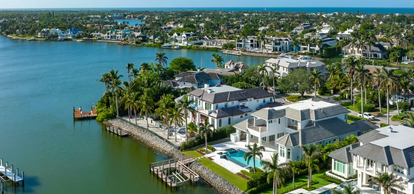 Naples luxury canal homes with private docks and pools along a wide waterway