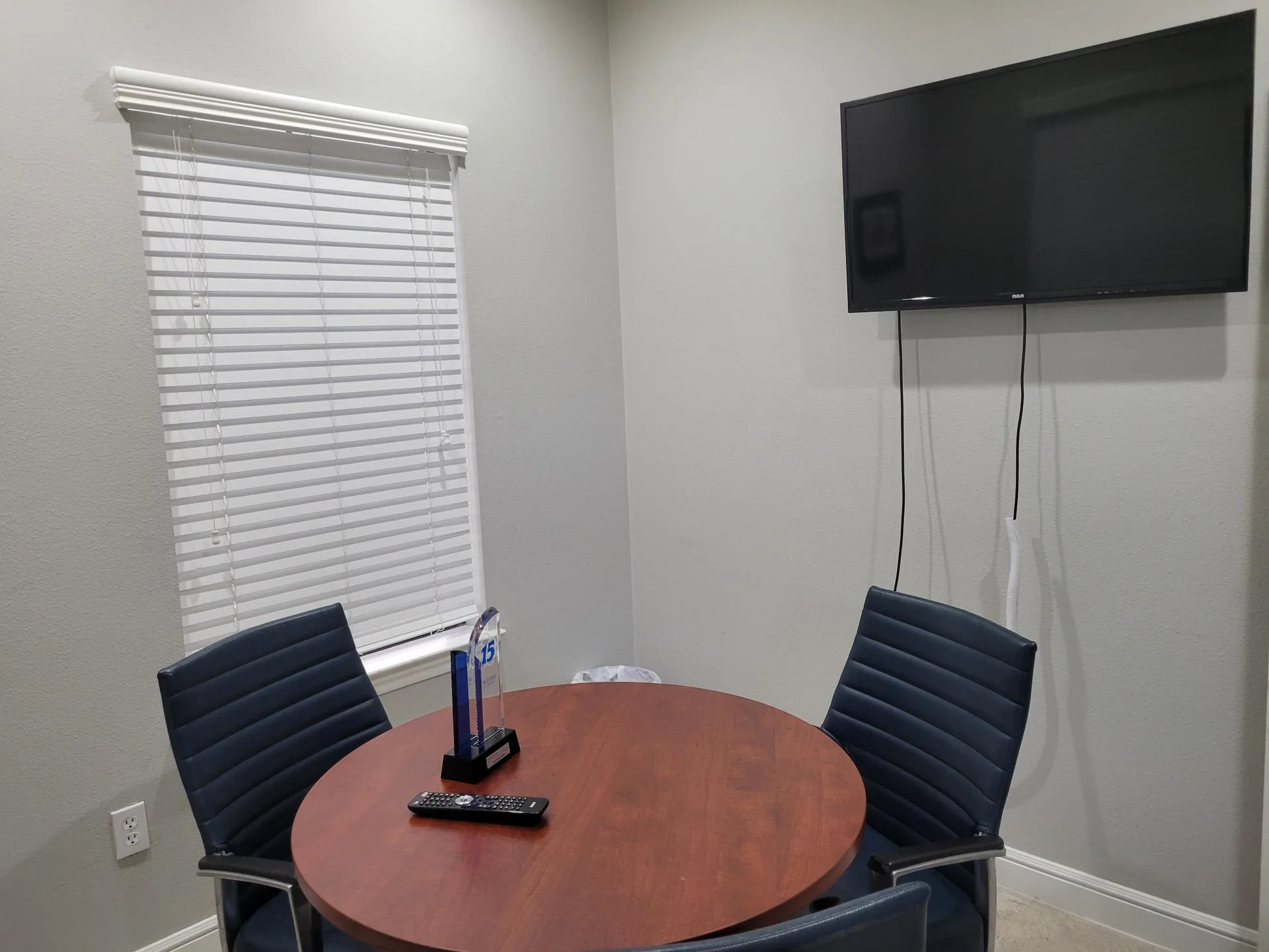 Shared workspace area with office chairs and a circular wood-top table at Provincial Professional Plaza