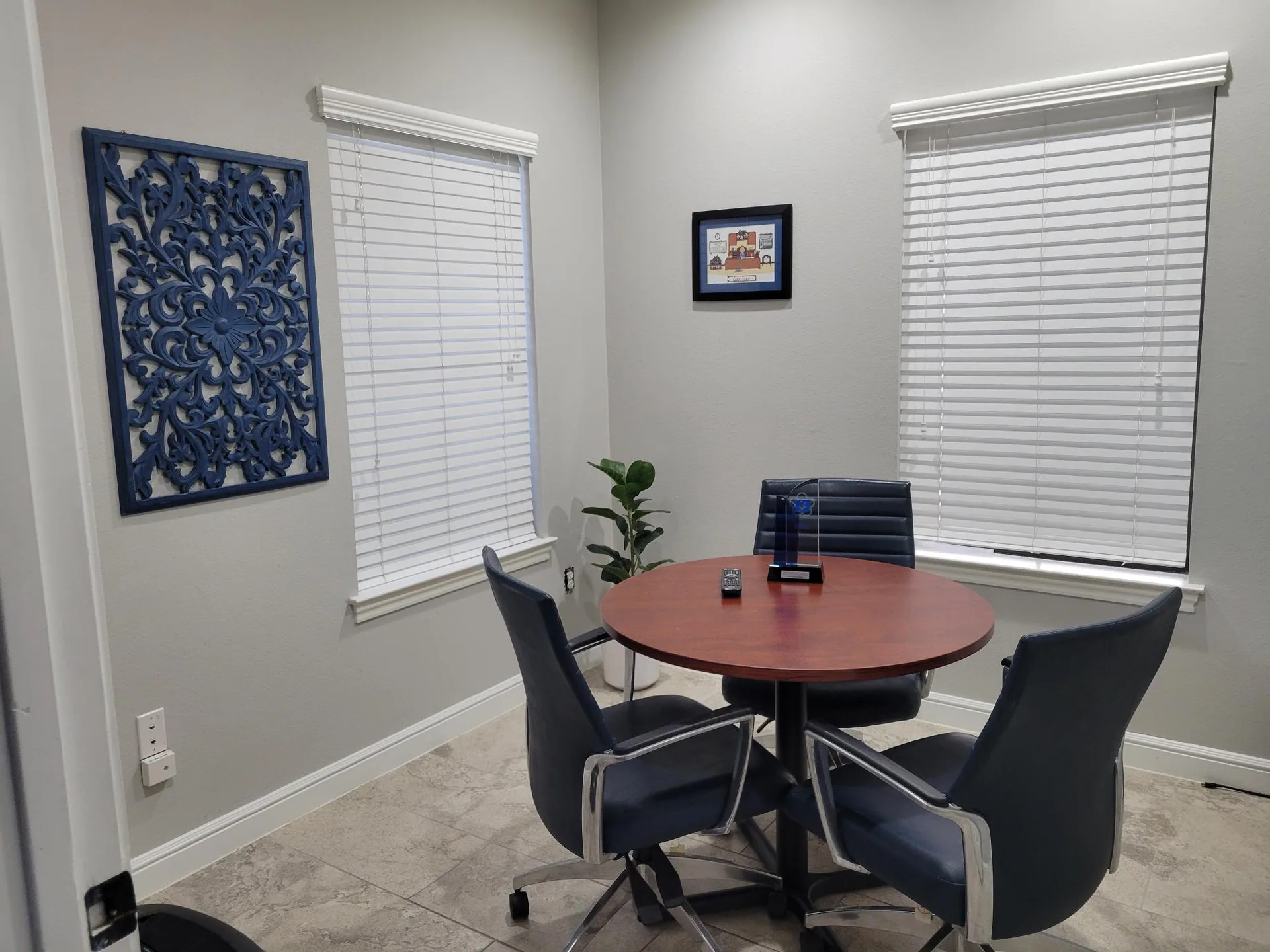 Private office with a round conference table, chairs, and window blinds at Provincial Professional Plaza