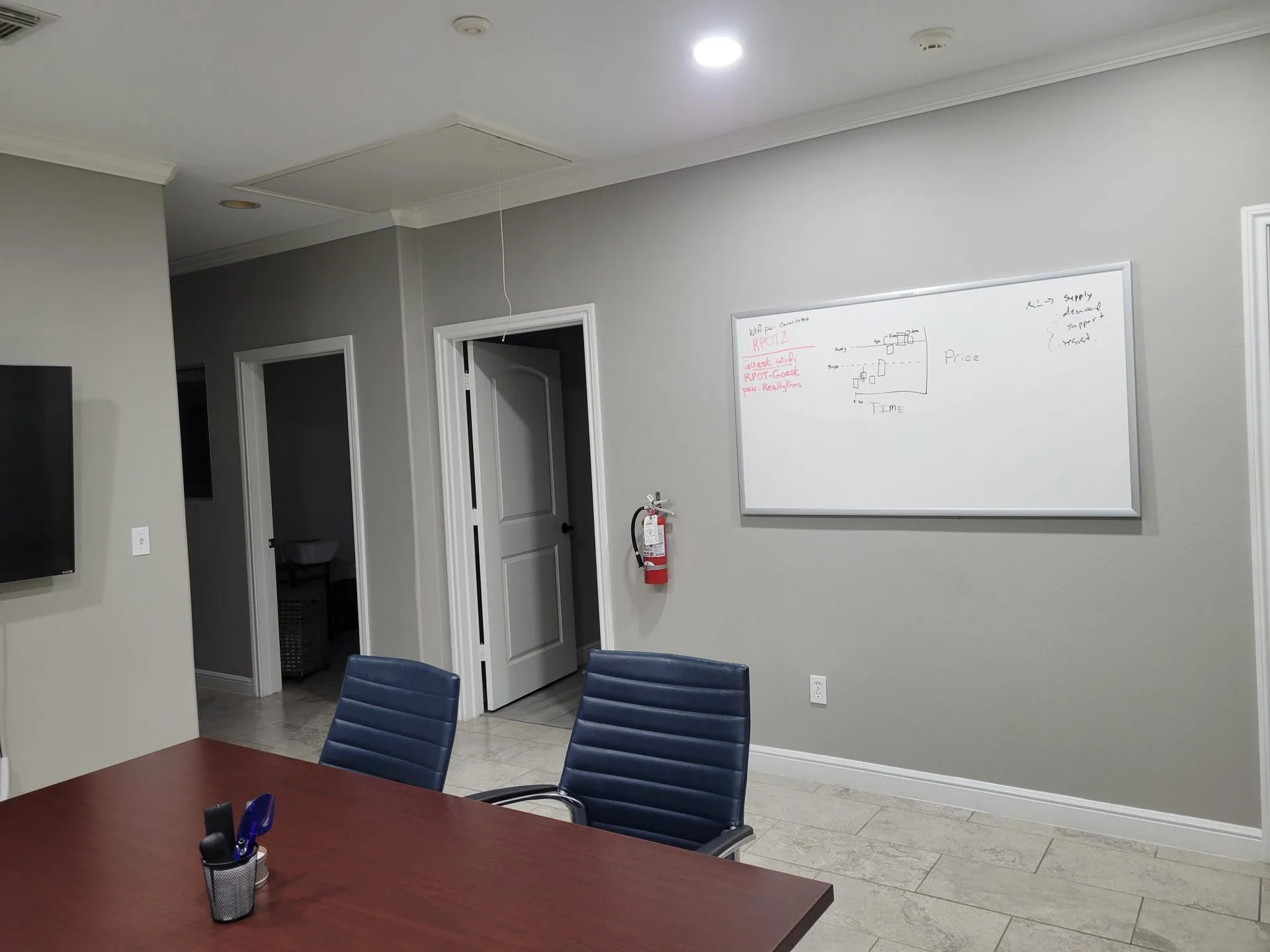 Executive office with a wood conference table, leather chairs, and a whiteboard at Provincial Professional Plaza