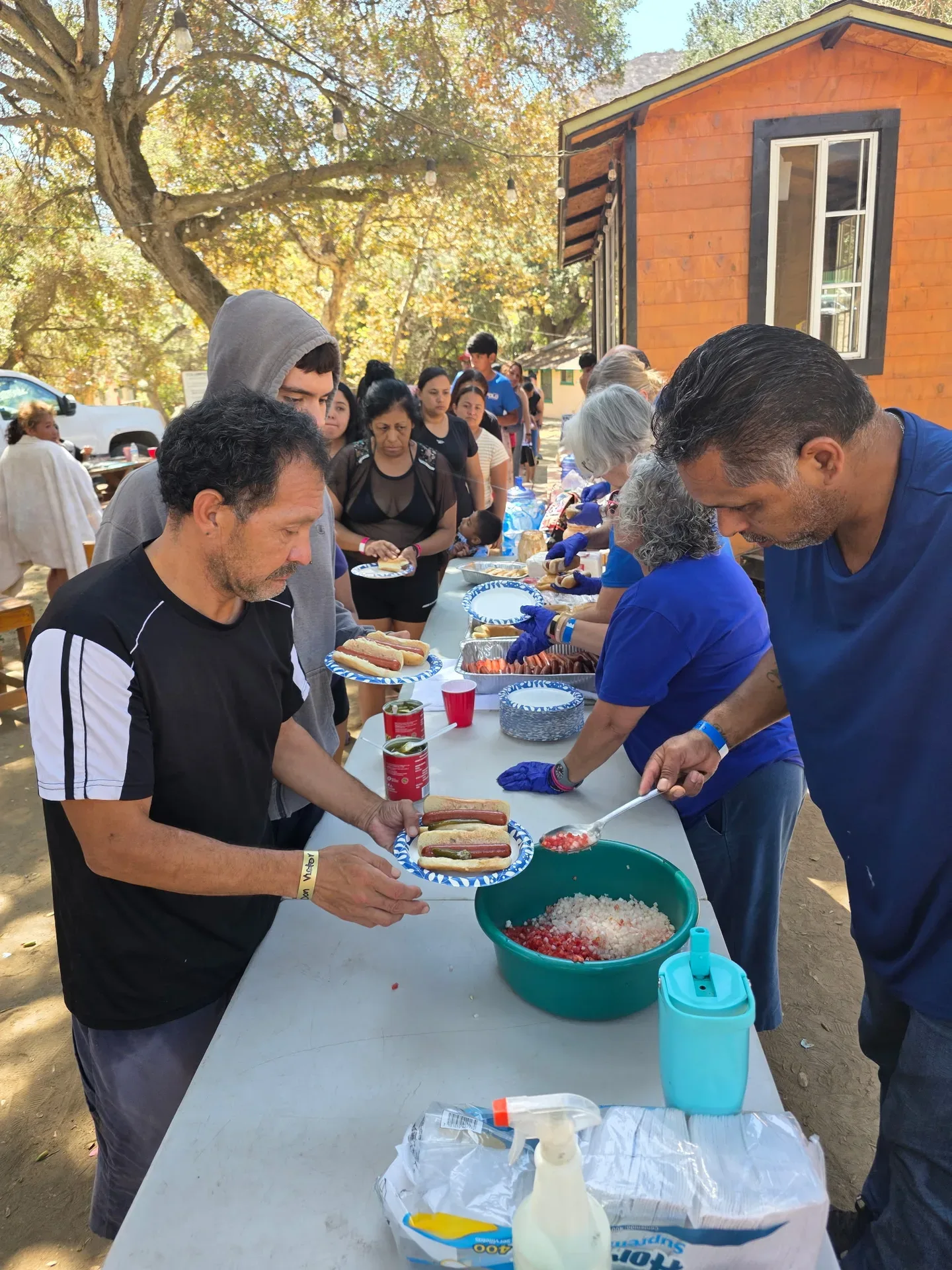 Serving lunch at Brenda's event, with a food line at the outdoor gathering
