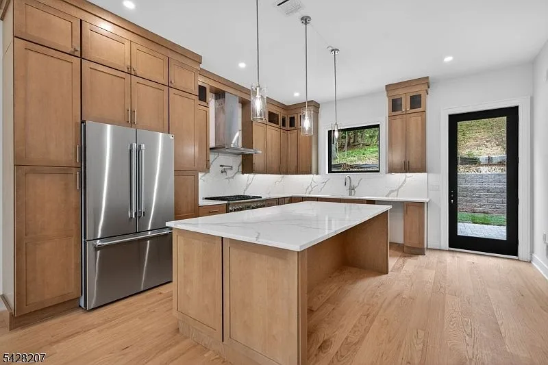 Modern kitchen with light wood cabinetry and quartz island