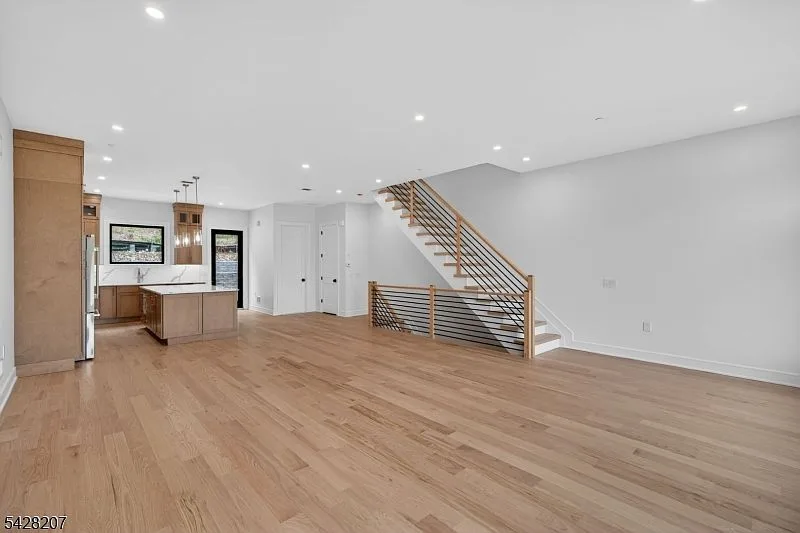 Open-concept living room with hardwood floors and recessed lighting