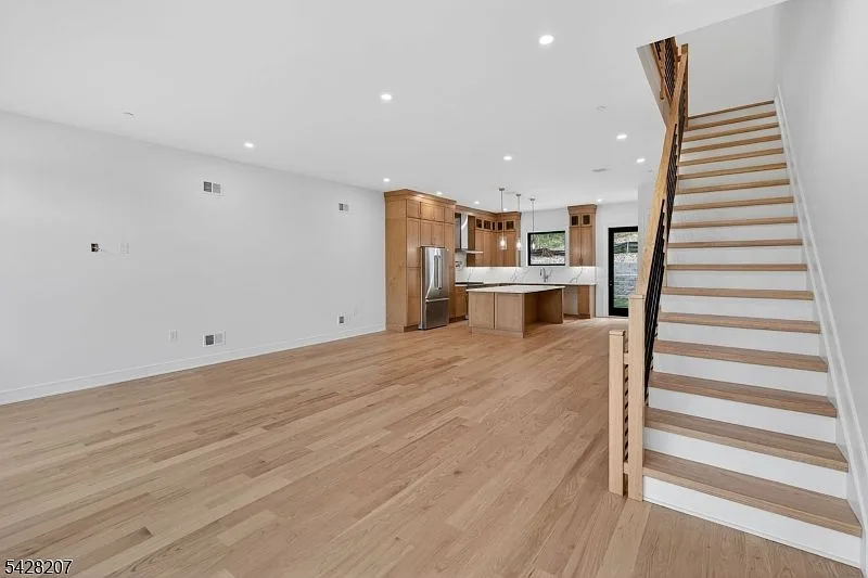 Open-concept living area connecting kitchen and staircase