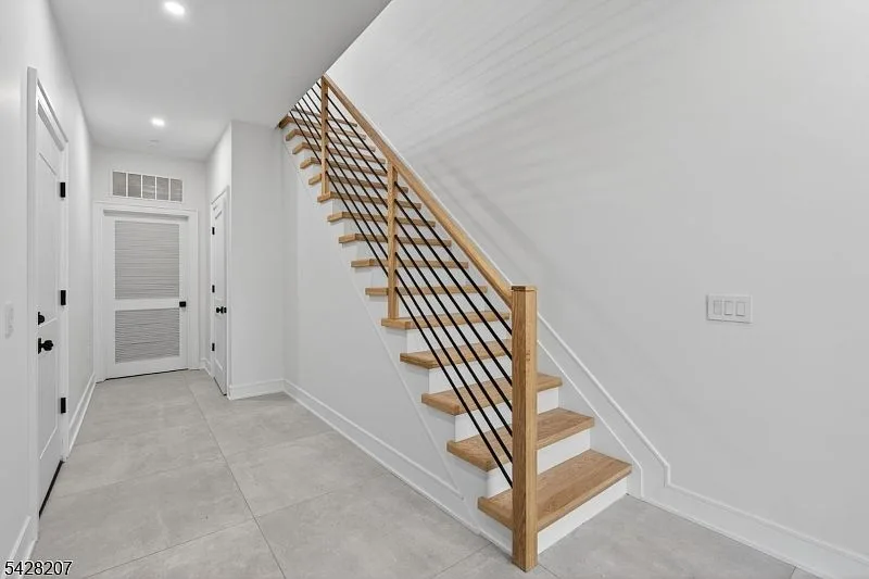 Entry foyer and staircase with light oak treads and black railings