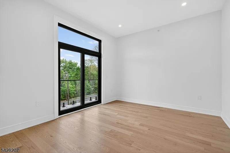 Bedroom with black-framed sliding door opening to a balcony