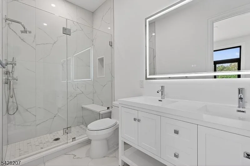 Primary bathroom with double vanity and frameless glass shower