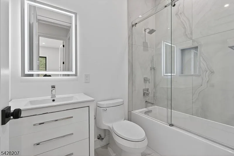 Primary bath with floor-to-ceiling marble-look wall tile