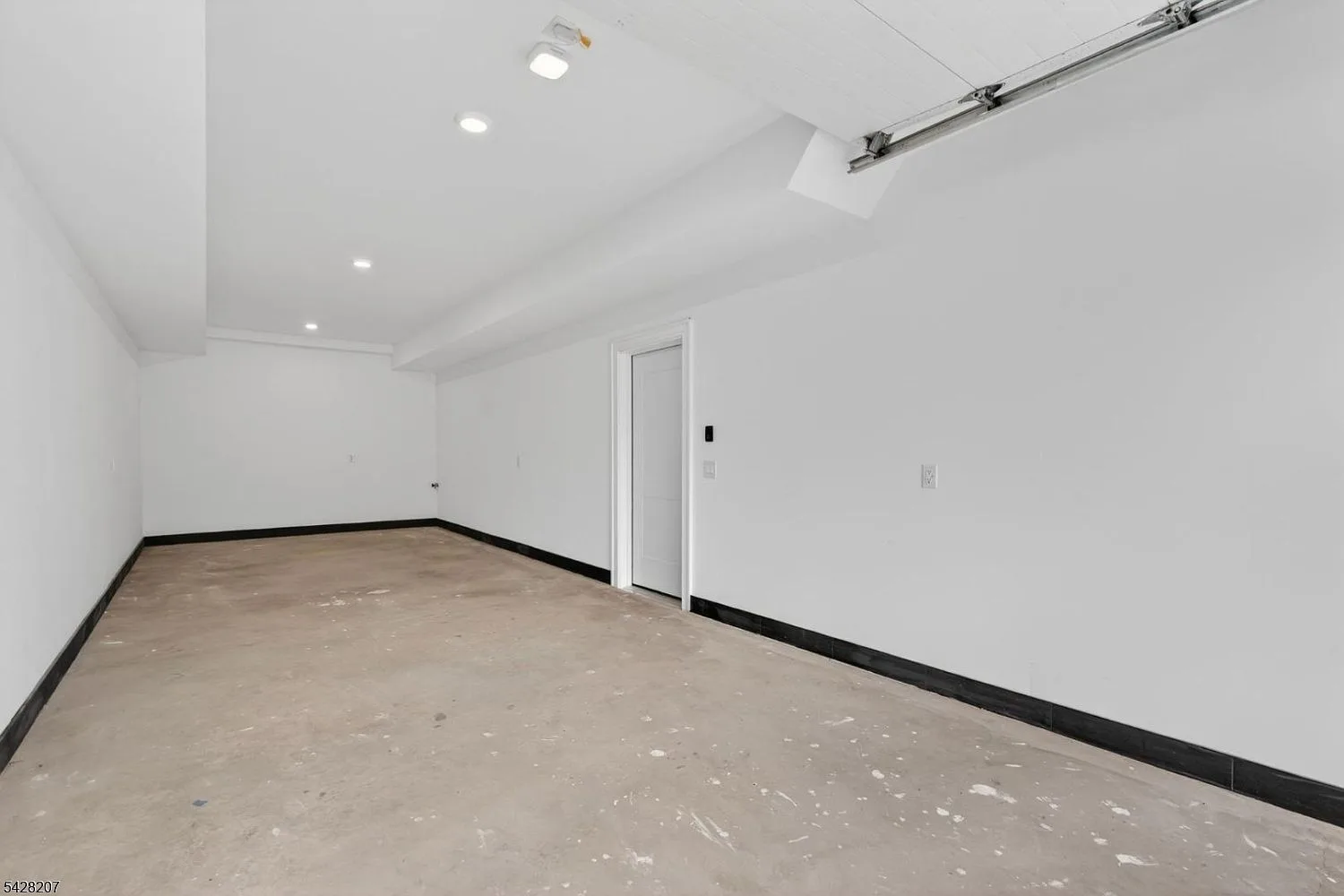 Two-car tandem garage on the entry level with white walls