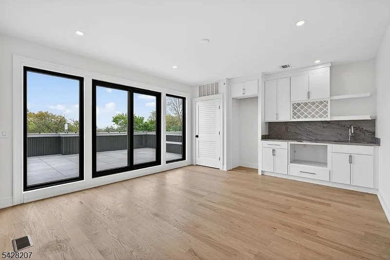 Rooftop lounge with a small wet bar and floor-to-ceiling doors