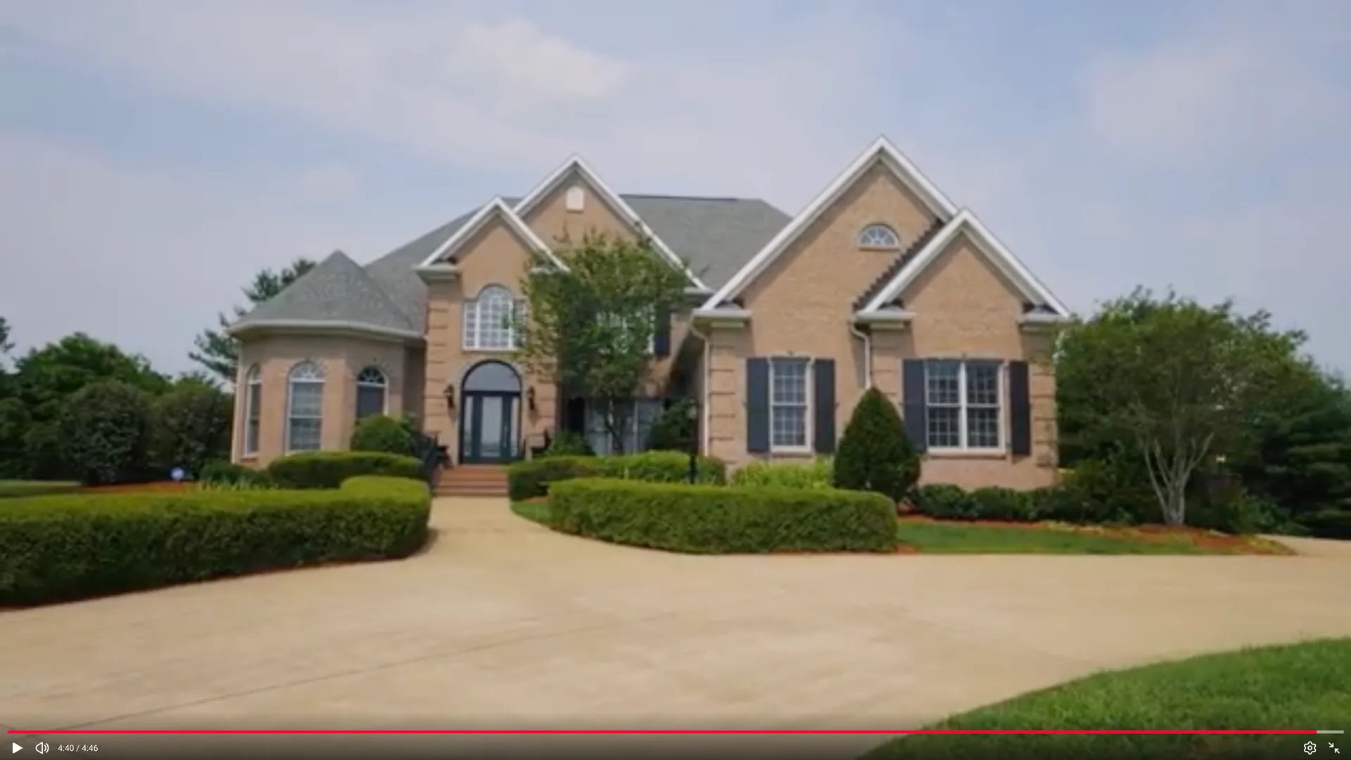 Front facade of a traditional tan-brick home with dark shutters and a landscaped lawn, a typical Warren County listing