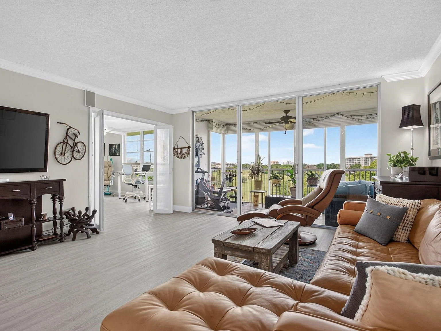 Living room at 2901 S Palm Aire Drive #610 with glass doors to the golf course view