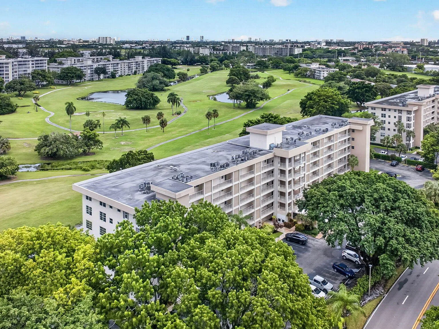 Aerial view of the building, golf course, and lake