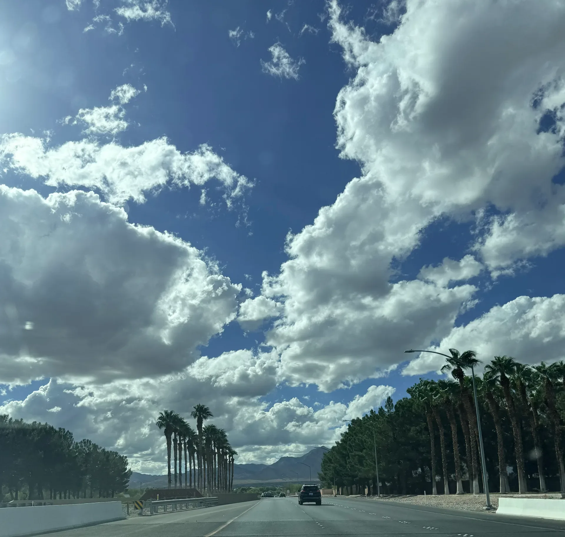 Summerlin Parkway multi-lane freeway with palm trees and mountains in the distance