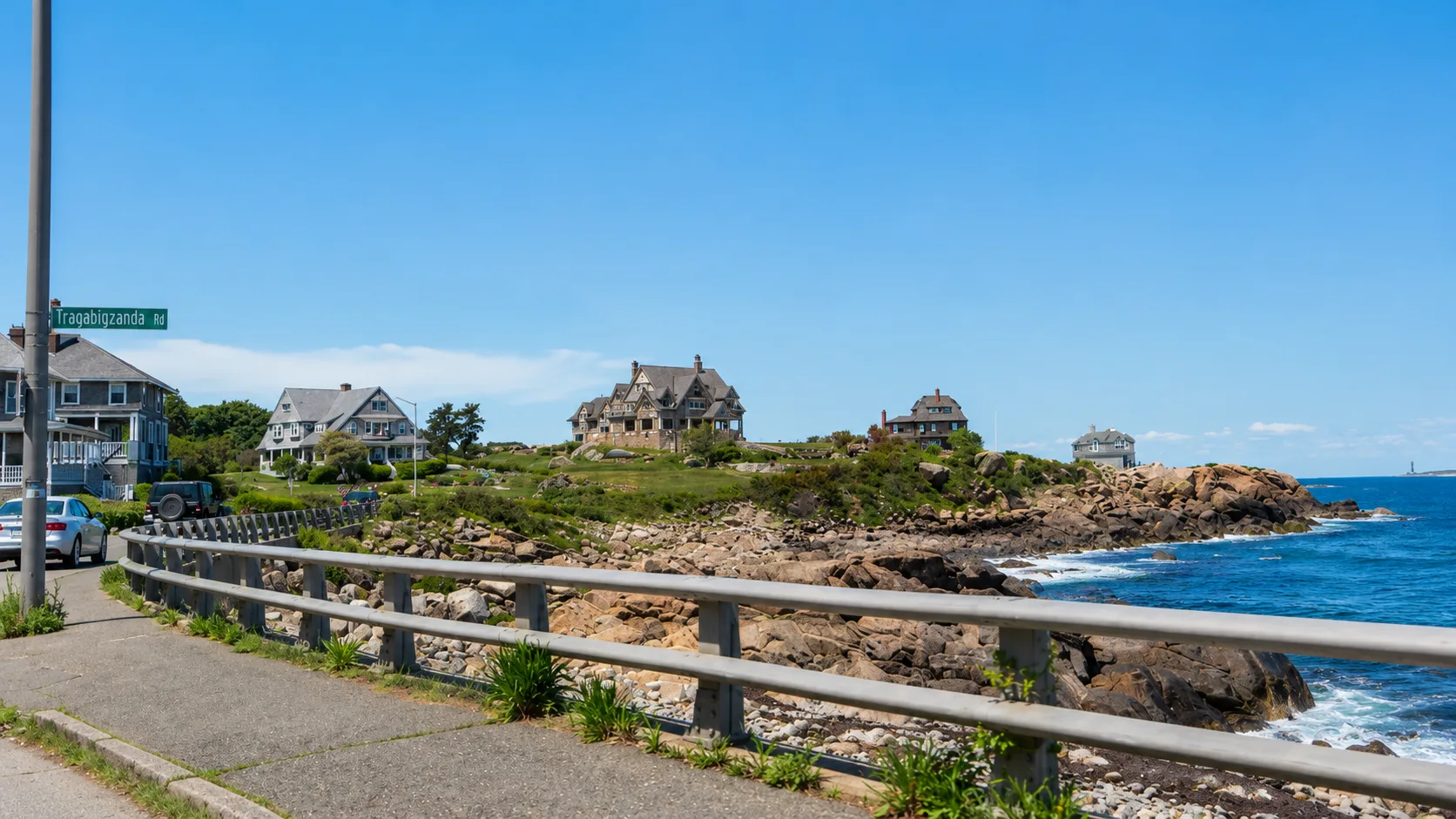 Coastal shingle-style homes along a rocky North Shore shoreline