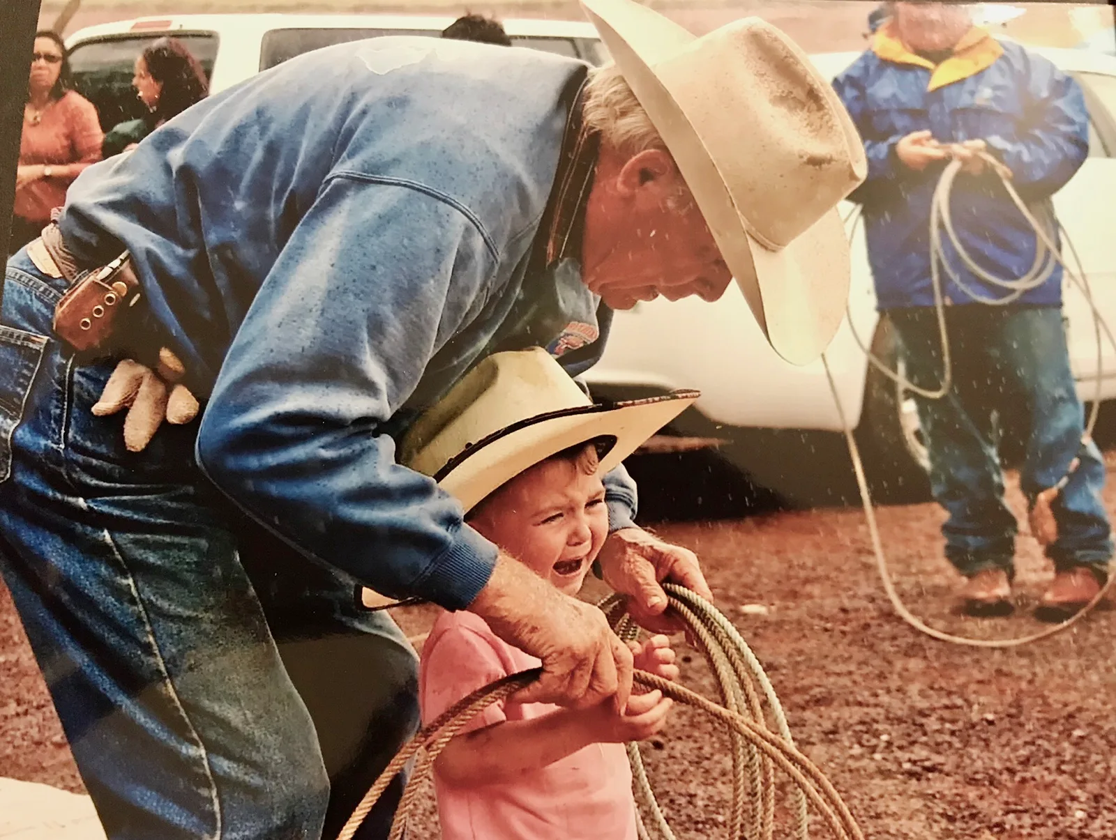 A paniolo teaching his granddaughter to rope at a rodeo near Waimea