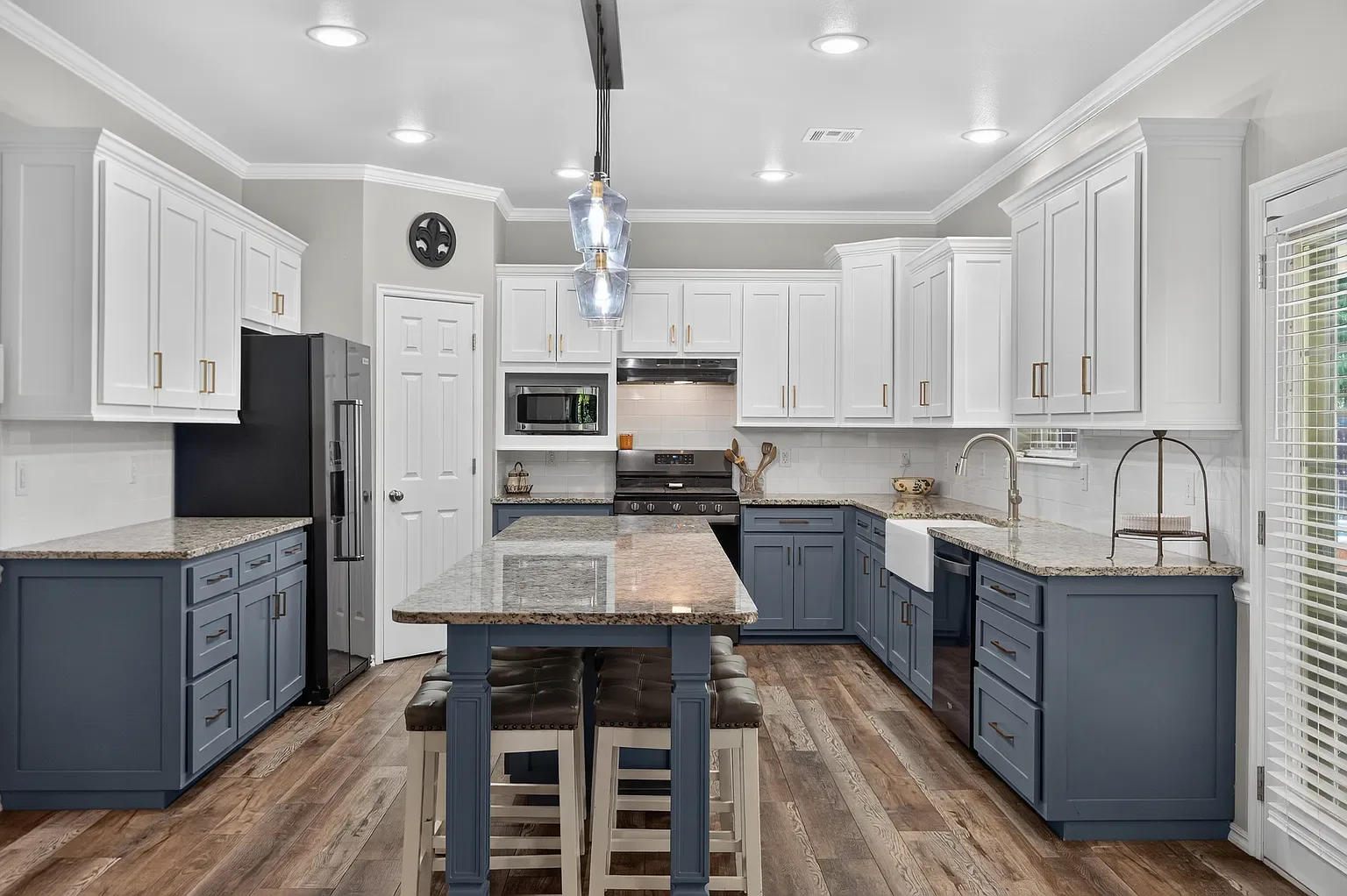 Two-tone navy and white kitchen island with granite counters
