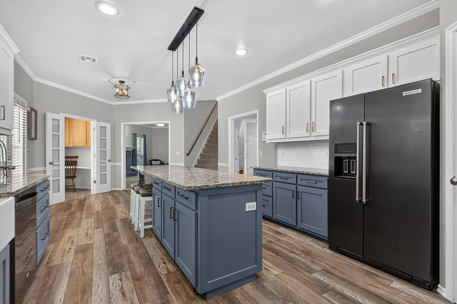 Kitchen with navy island and white upper cabinets