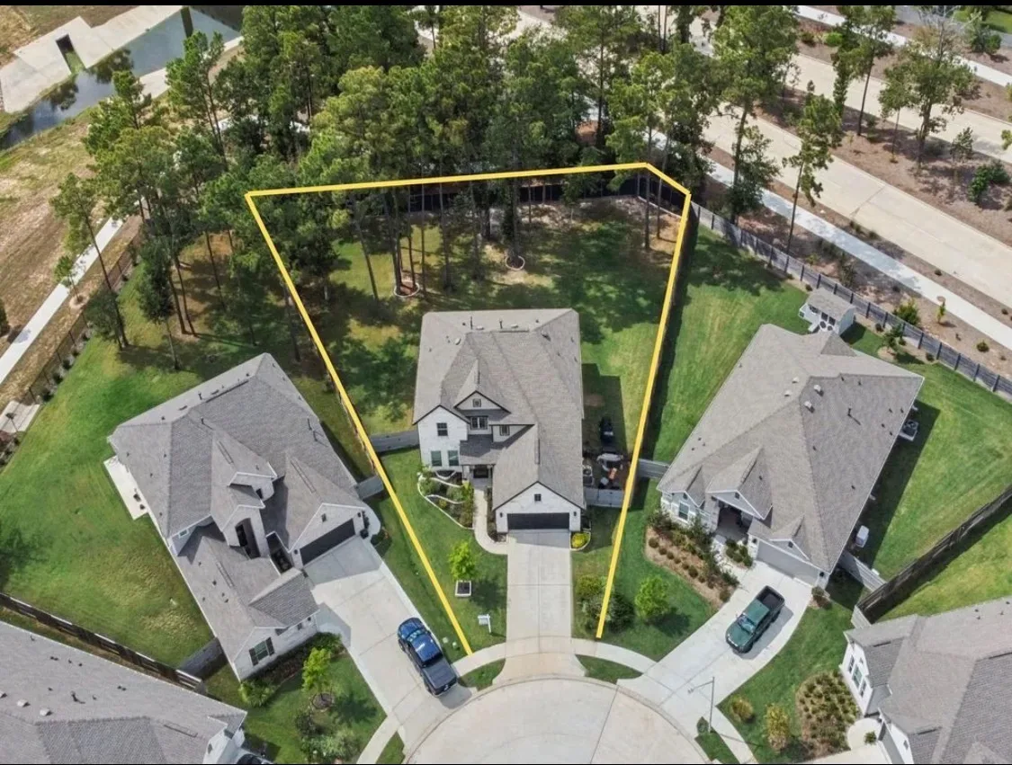 Aerial drone view of 15500 Leopard Lily Ln on its cul-de-sac lot, showing the home and its street position among neighboring houses