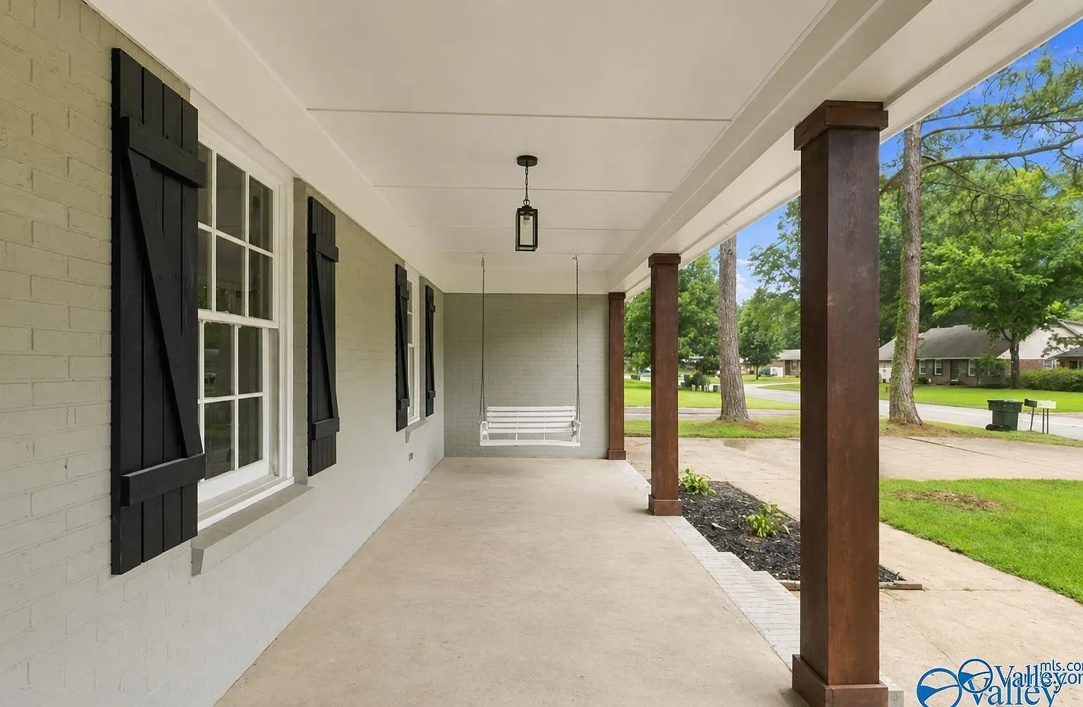Front porch with wood columns and a white porch swing