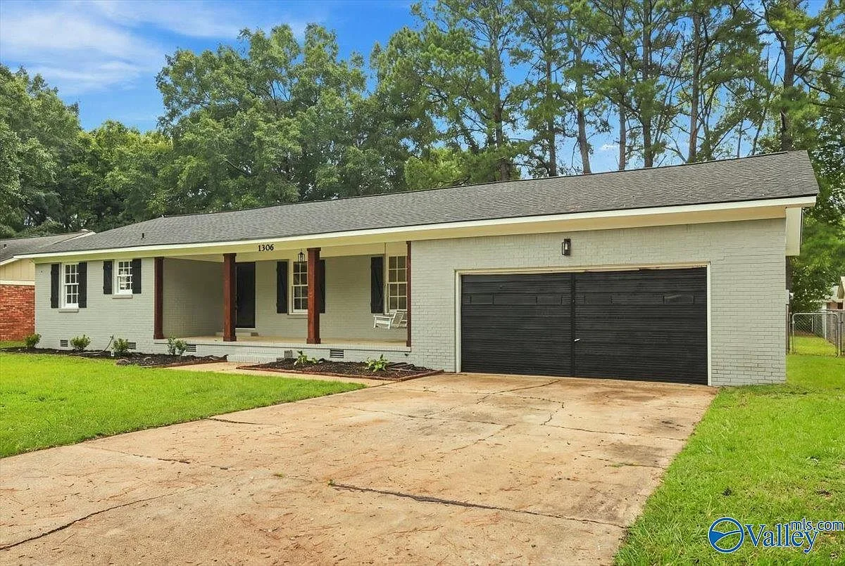 The renovated ranch house at 1306 Garth Ave SW, light gray brick facade with a front porch and swing