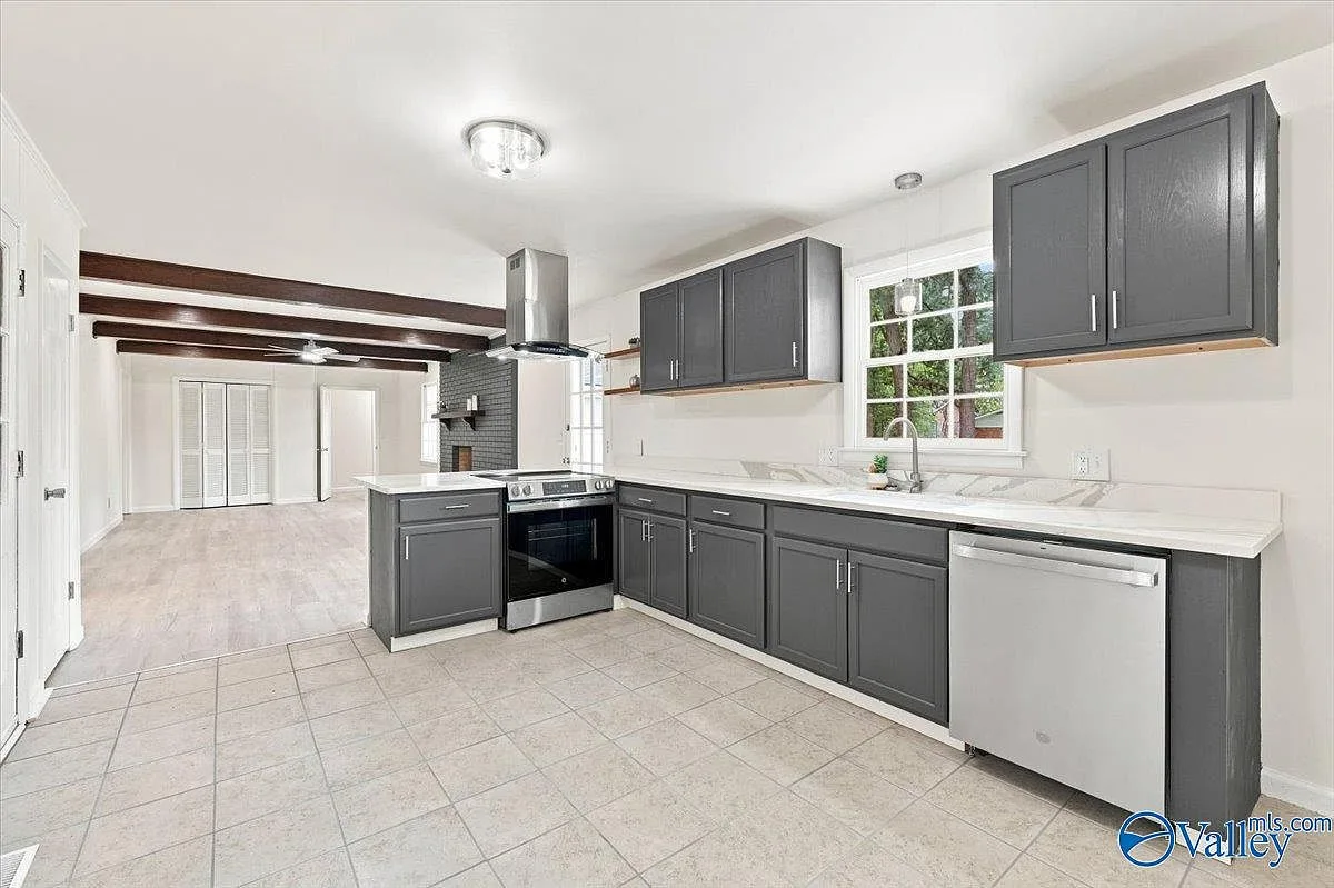 Renovated kitchen with dark gray cabinets, quartz counters, and stainless steel appliances