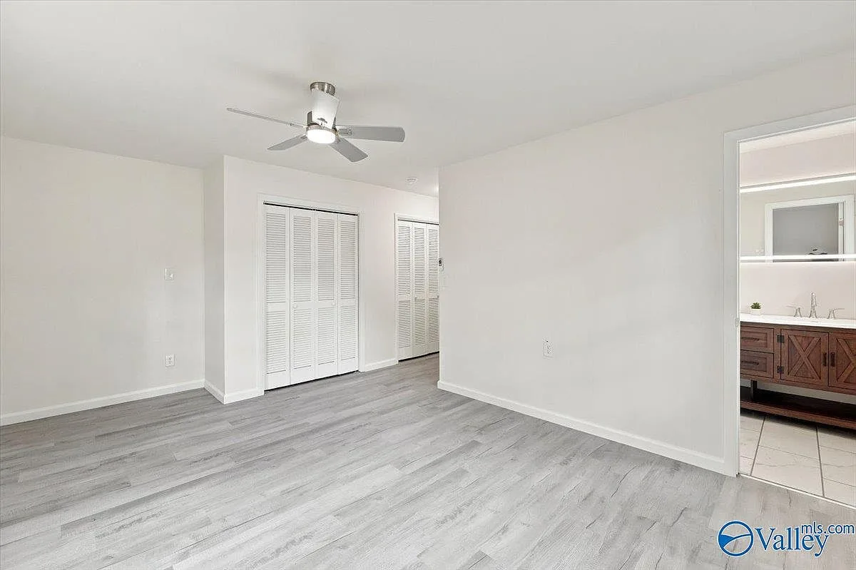 Primary suite with closet doors and an entrance to the primary bath