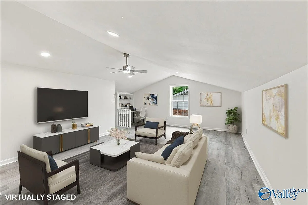 Wide living room with a vaulted ceiling and wood-look flooring