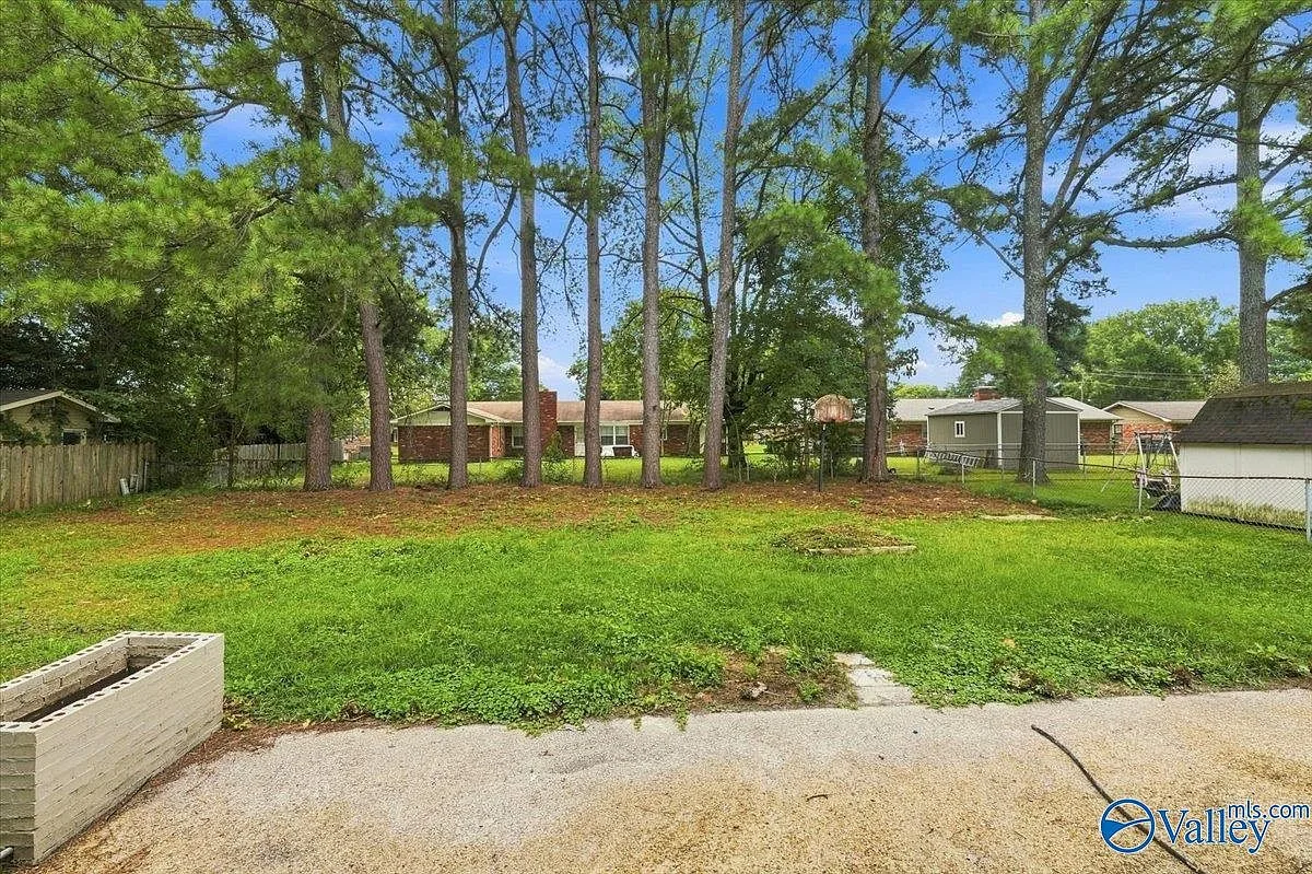 Spacious backyard with mature trees and a lawn