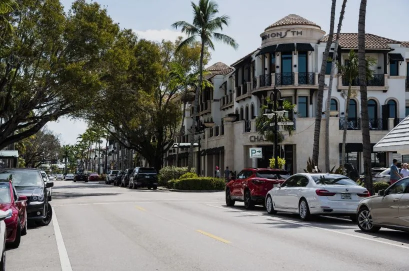 Mediterranean-style mixed-use building with arched windows and tile roof on a downtown Naples street