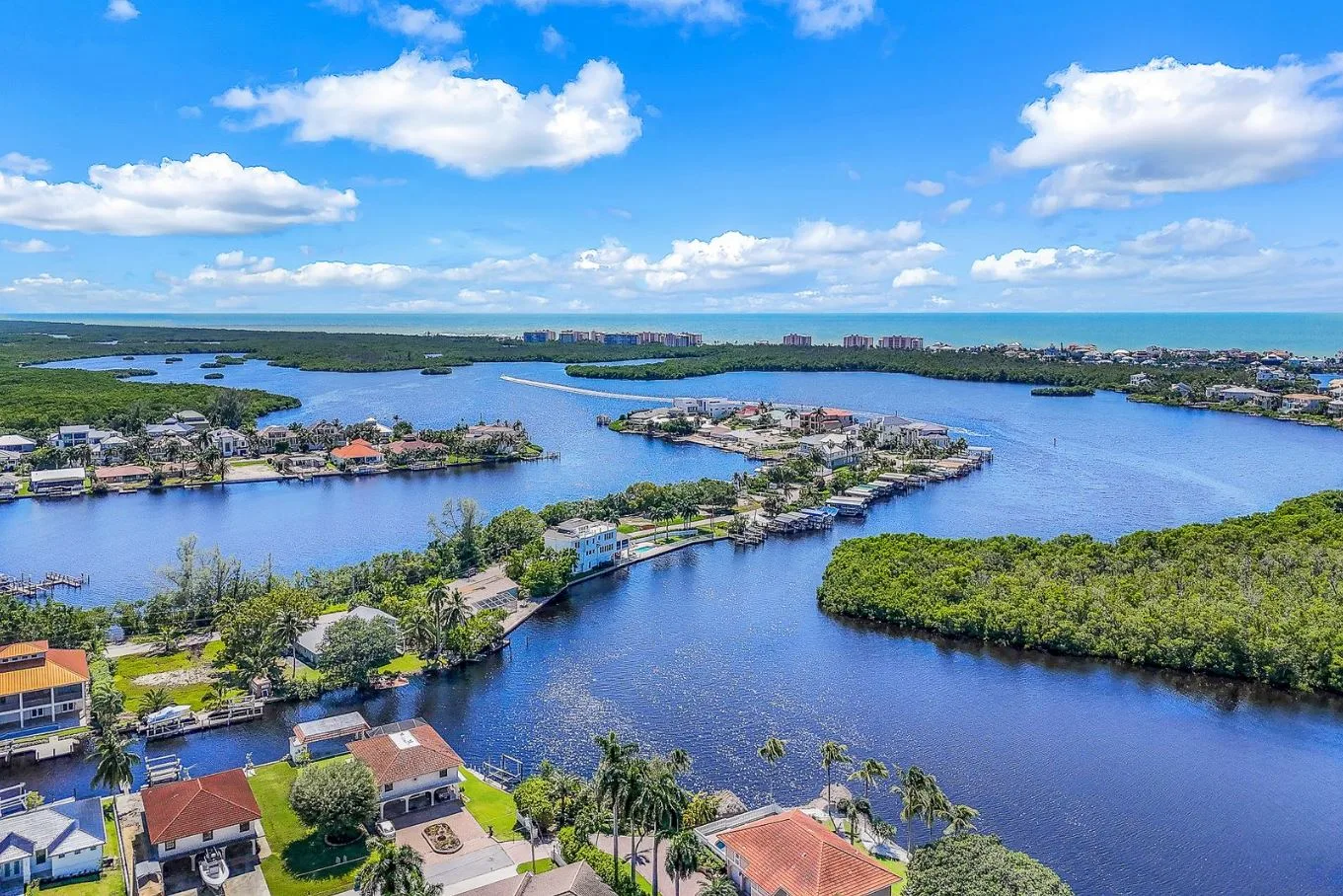Aerial view of Bonita Springs waterfront homes along canals and mangroves with private boat docks
