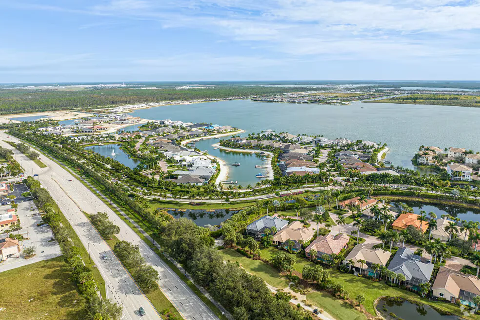 Aerial view of a waterfront Estero community with lagoons, canals, and single-family homes