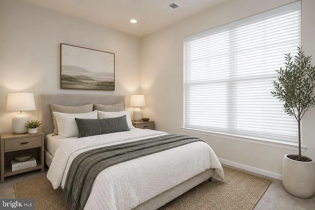 First-level guest bedroom with a bed, nightstands, and natural light