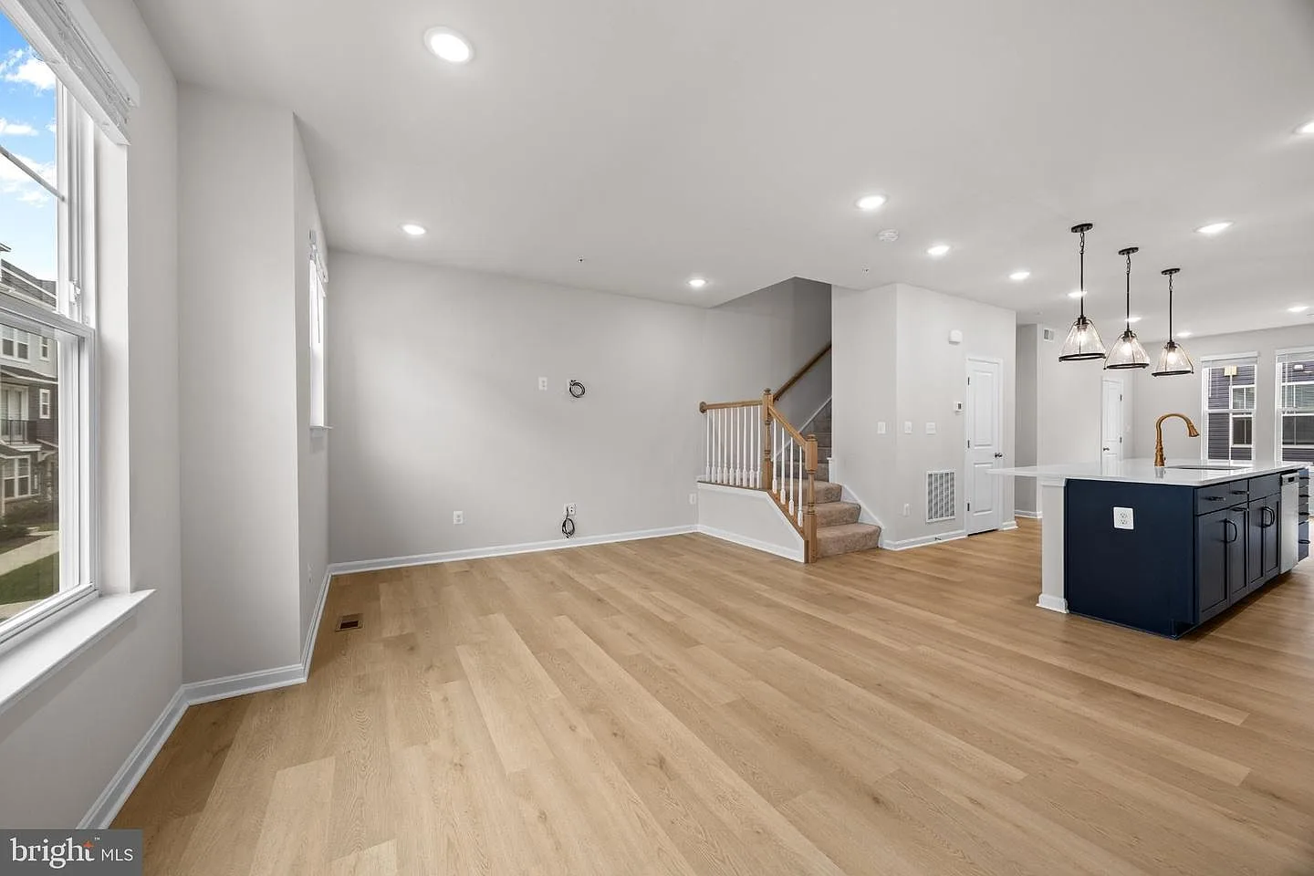 Open-concept living and kitchen area with a navy island and quartz countertops